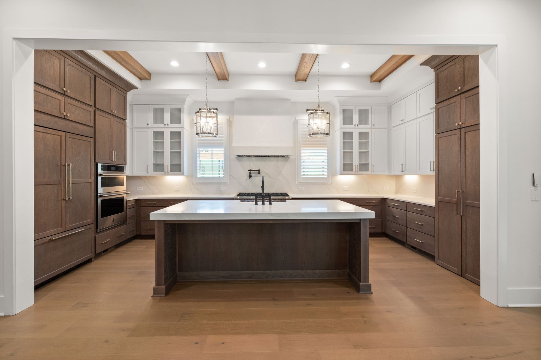Kitchen with warm wood cabinetry, white cabinets, and a central island
