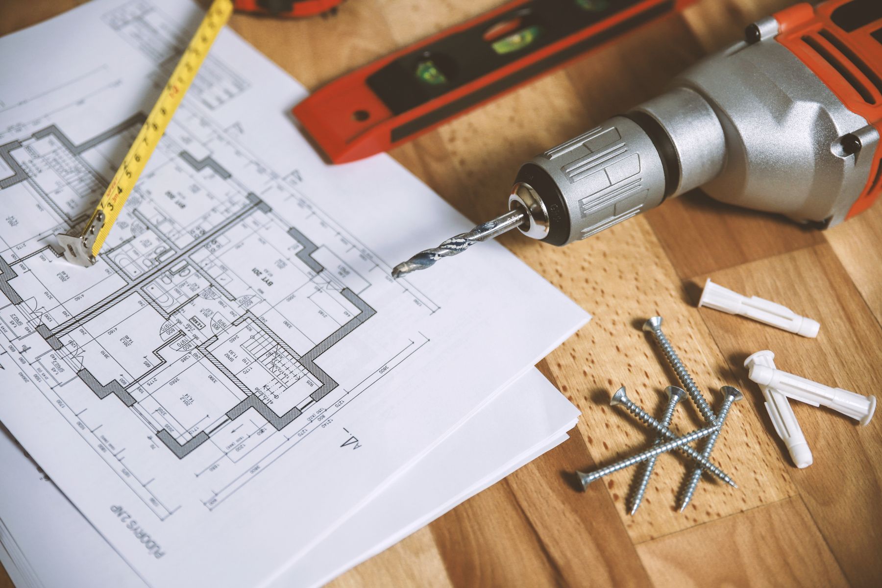 House plan with a tape measure, drill, and screws