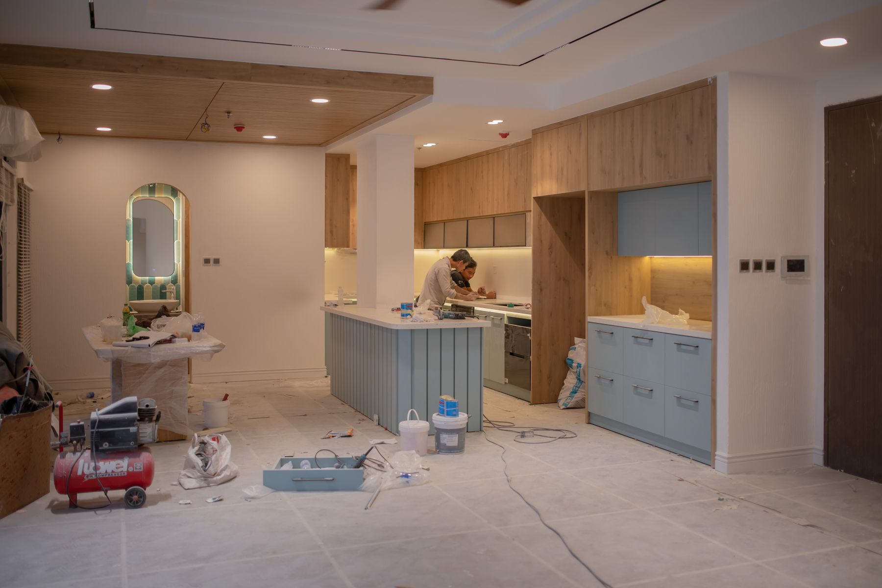 Kitchen renovation in progress with workers and tools